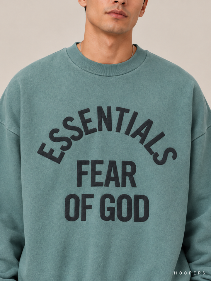 סווטשירט Fear of God Essentials – Arch Logo טורקיז מכובס – תקריב