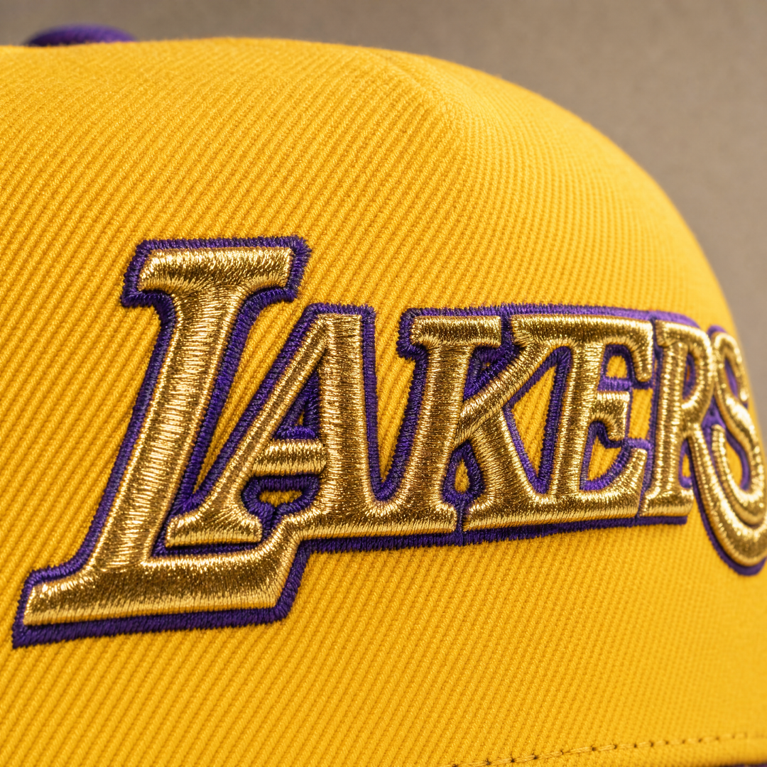 רקמת כיתוב LAKERS בזהב מטאלי על בד צהוב - מאקרו