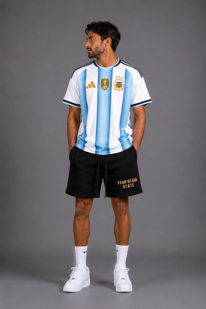 Hoopers sky blue and white striped Argentina soccer jersey with gold details. Model wears black shorts.
