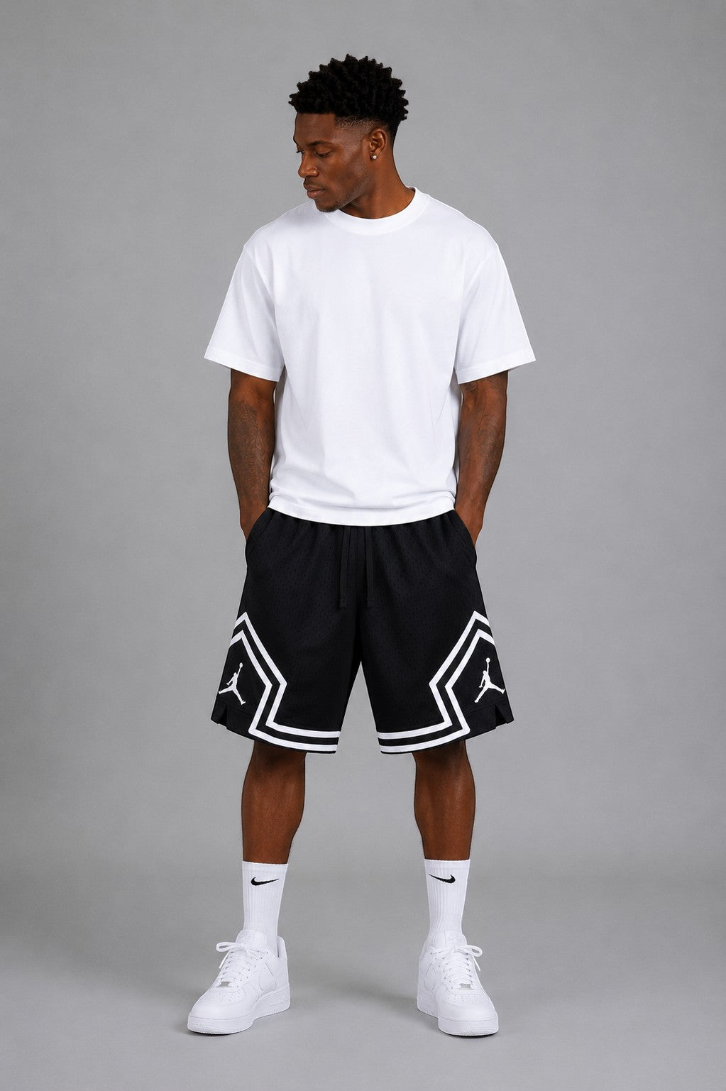 Hoopers black mesh basketball shorts with white trim and Jordan logo on a man wearing a white t-shirt.
