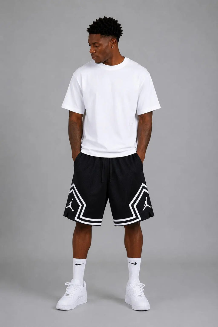 Hoopers black mesh basketball shorts with white trim and Jordan logo on a man wearing a white t-shirt.