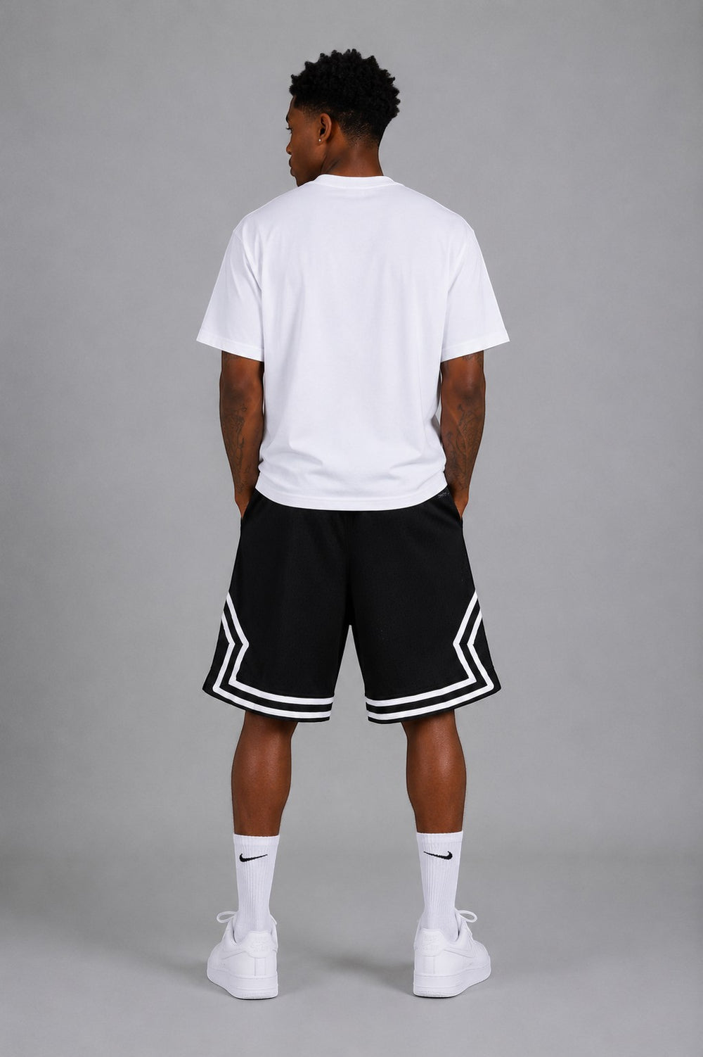 Hoopers black mesh basketball shorts with white trim and side accents, worn by a man.