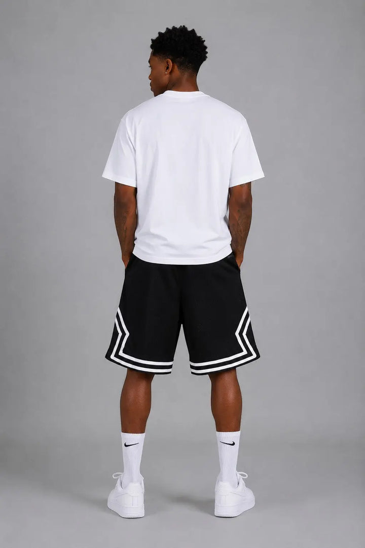 Hoopers black mesh basketball shorts with white trim and side accents, worn by a man.