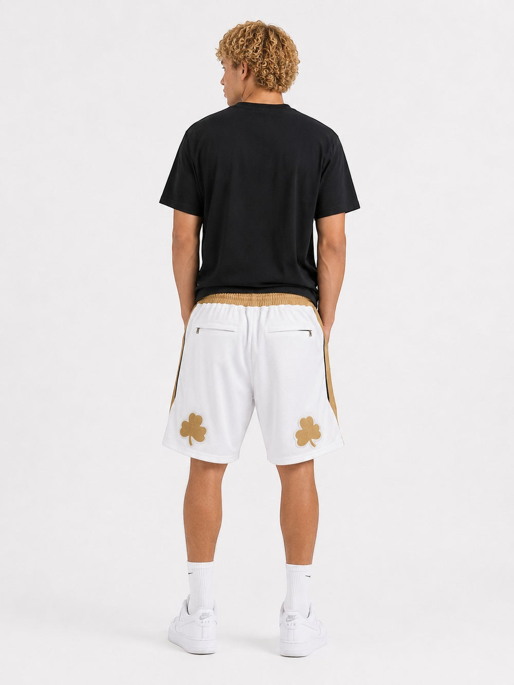Hoopers white basketball shorts with gold trim and clover logos, featuring a relaxed fit and breathable mesh fabric.