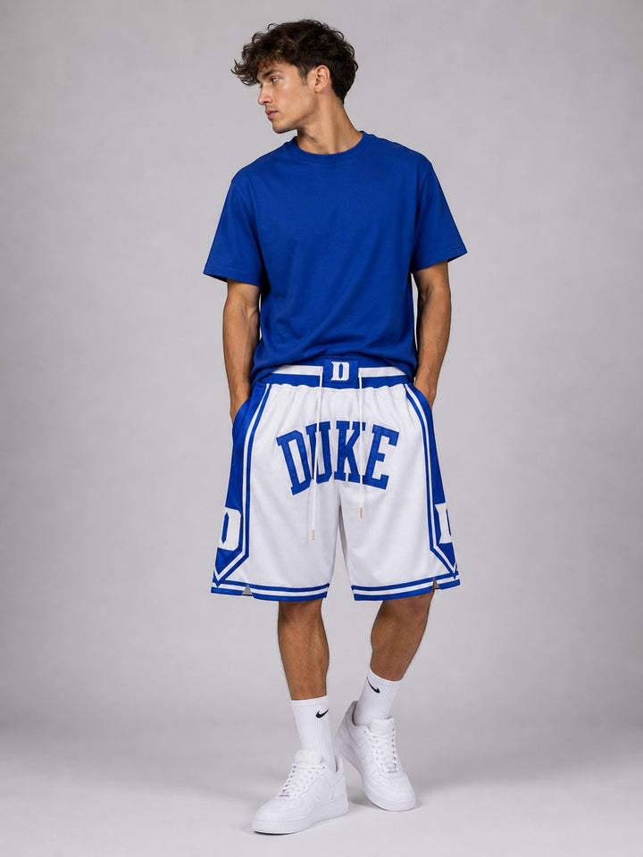 Hoopers white and blue mesh NBA shorts with "DUKE" lettering and side panel details. Model is wearing a blue t-shirt.