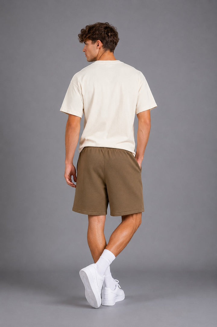 Hoopers Fear Of God Desert State olive khaki sweat shorts with drawstring and side pockets on a male model.