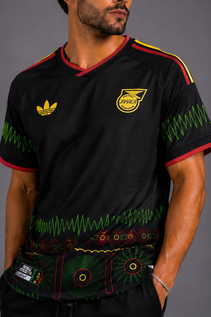 Hoopers black Jamaica World Cup Soundwave Edition jersey with red and yellow trim, featuring reggae-inspired graphics and a relaxed fit.