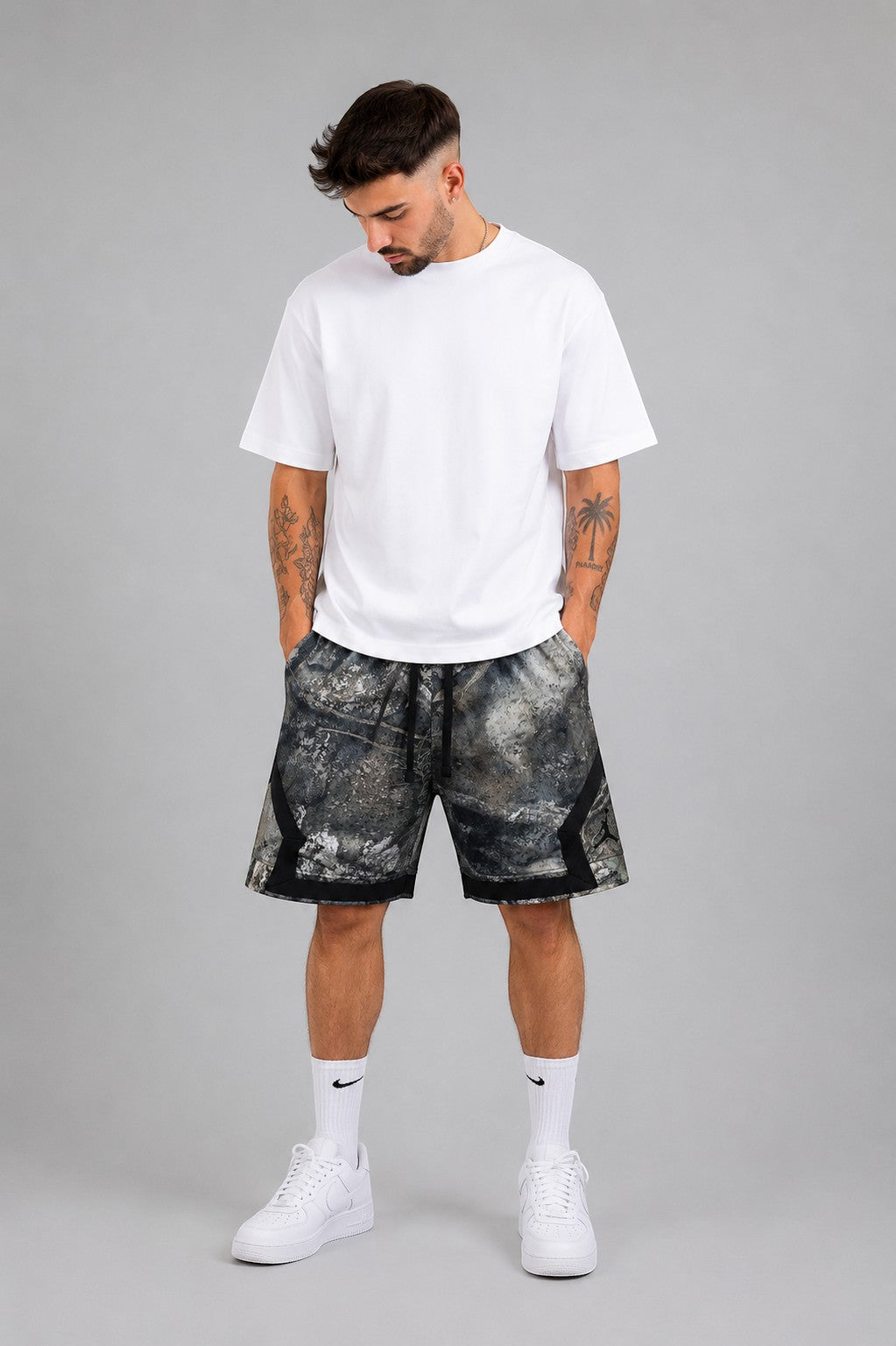 Hoopers Jordan Camo Stone shorts in grey, black, and stone woodland camo pattern. Loose fit, 100% polyester.