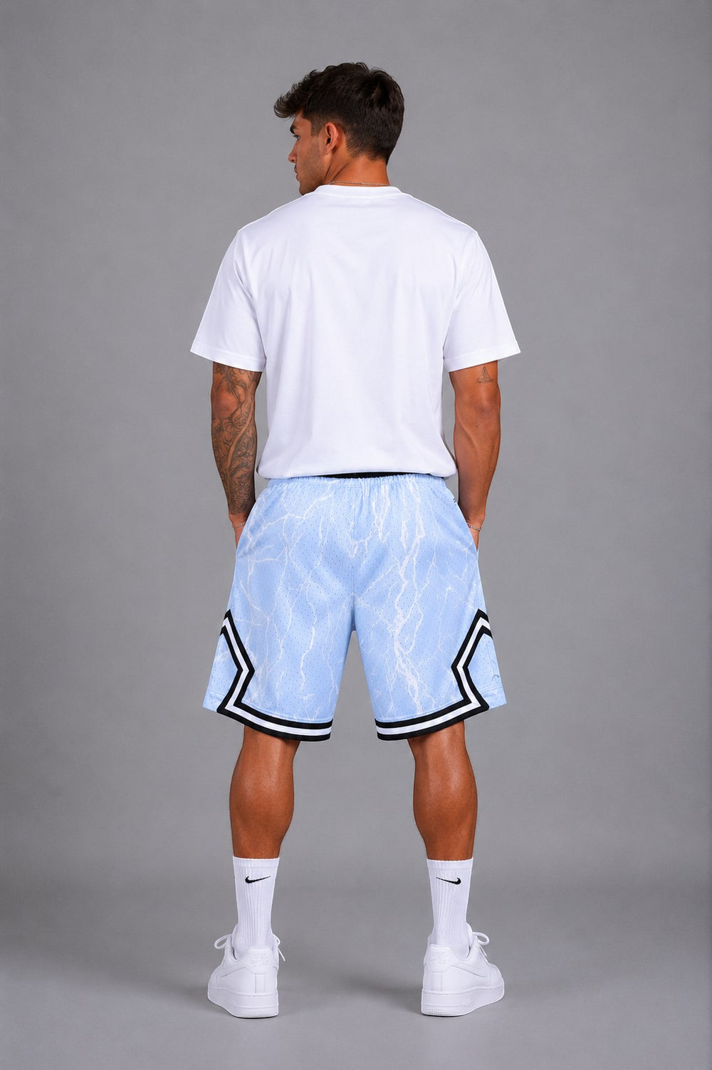 Hoopers light blue mesh basketball shorts with white lightning print and black trim. Model is wearing a white t-shirt.