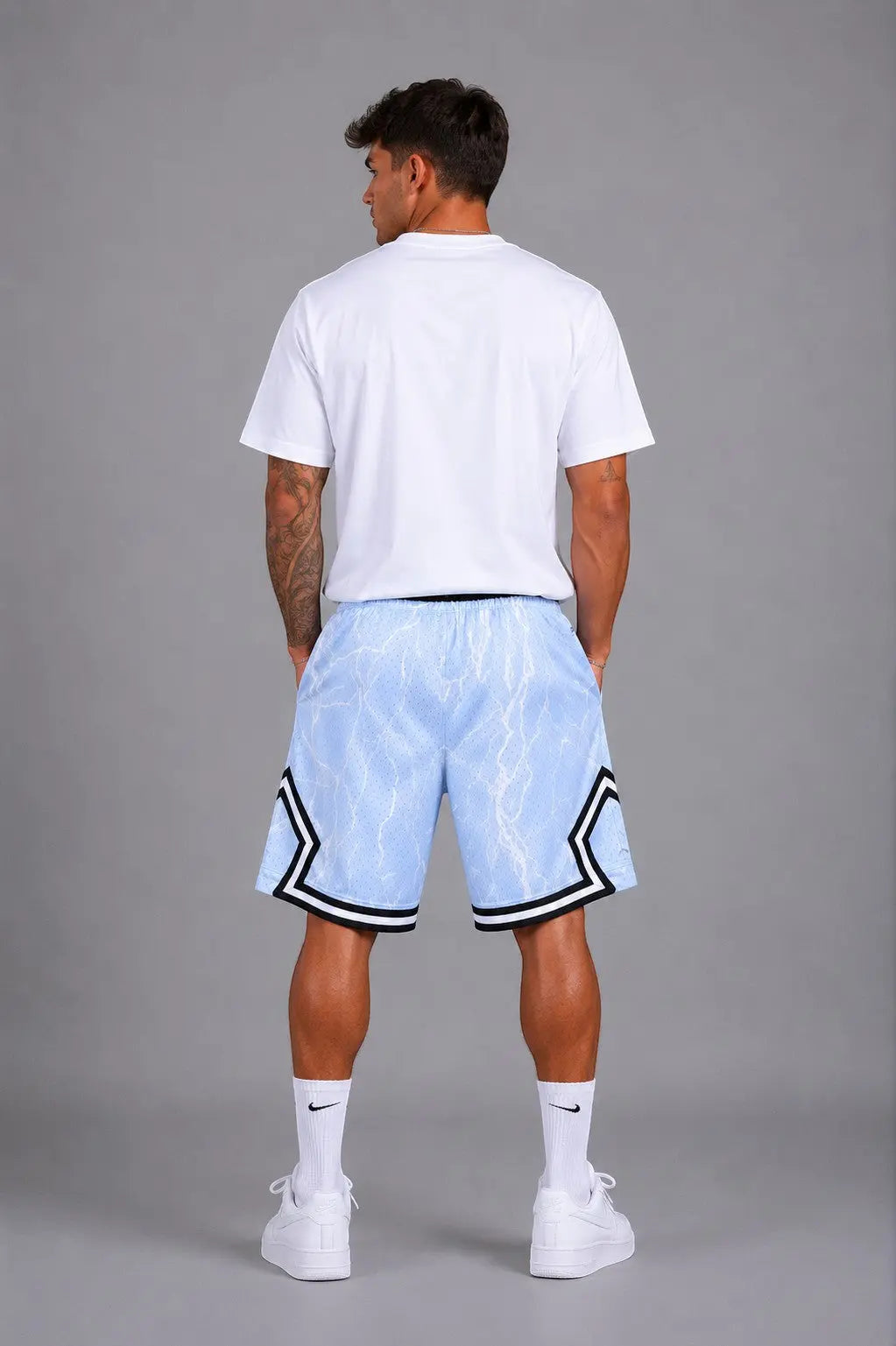 Hoopers light blue mesh basketball shorts with white lightning print and black trim. Model is wearing a white t-shirt.