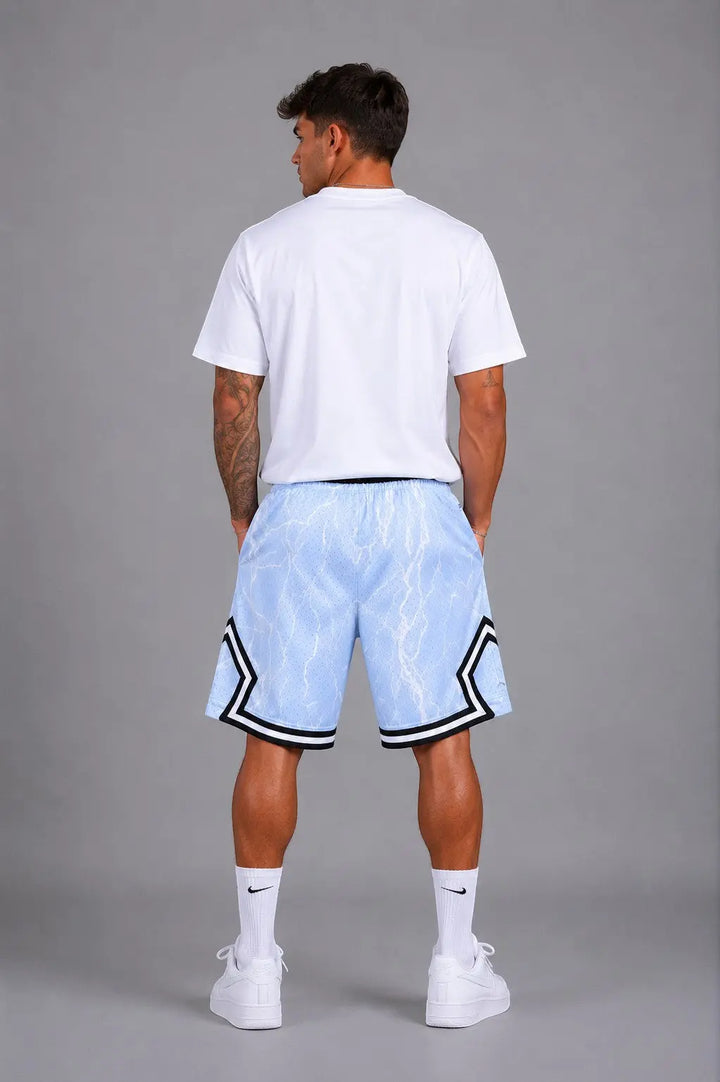 Hoopers light blue mesh basketball shorts with white lightning print and black trim. Model is wearing a white t-shirt.