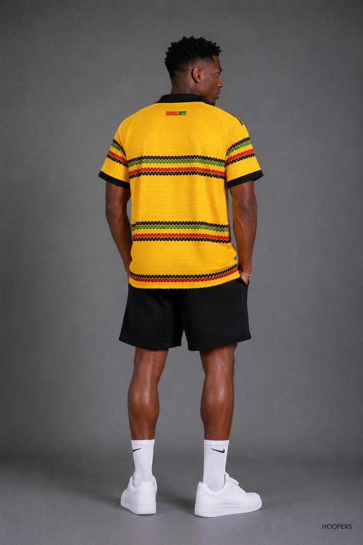 Hoopers yellow polo shirt with black collar and cuffs, featuring red, green, and black horizontal stripes and a textured knit. Inspired by reggae culture.
